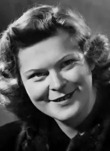 Porträt der 33-jährigen Gerda Mez. Sie hat dunkelblondes, schulterlanges Haar, das ihr rundes Gesicht umspielt. Sie lächelt an der Kamera vorbei. 