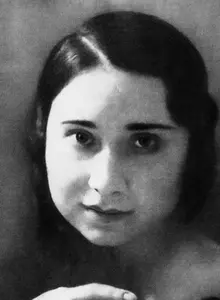Porträt von Käthe Tucholla. Sie hat schwarzes Haar, dass sie zu einem strengen Scheitel gekämmt hat und das ihr knapp über die Ohren reicht. Sie schaut direkt in die Kamera. 