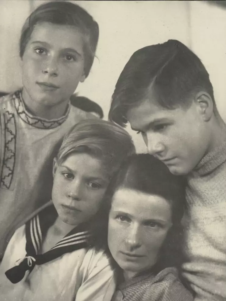 Emilie Bonhoeffer eng aneinandergekuschelt mit ihren drei Kindern. Der älteste ist etwa 16 Jahre alt, die mittlere Tochter etwa 14 Jahre alt und der jüngste etwa 8 Jahre alt. Der jüngste Sohn trägt einen Matrosenanzug.  