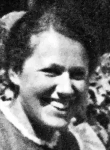 Barbara von Haeften steht im Freien und lacht in Richtung der Kamera. Sie hat schwarzes, gescheiteltes Haar. 